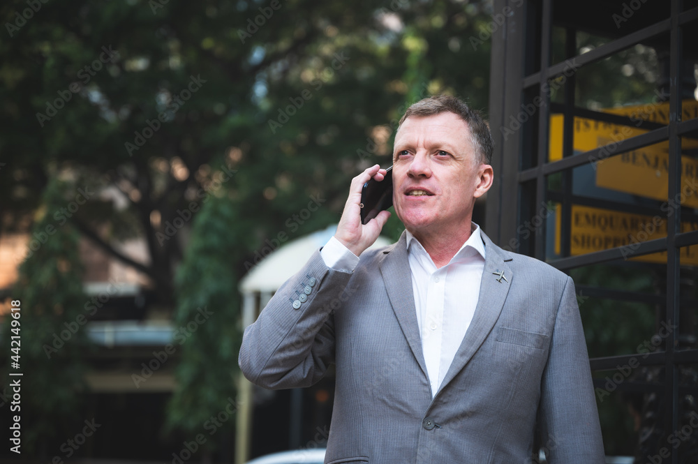 handsome executive manager businessman in suit using touch smart mobile phone to work on cyberspace, confident and successful with cellphone online message, walking in the city handsome executive manager businessman in suit using touch smart mobile phone to work on cyberspace, confident and successful with cellphone online message, walking in the city
