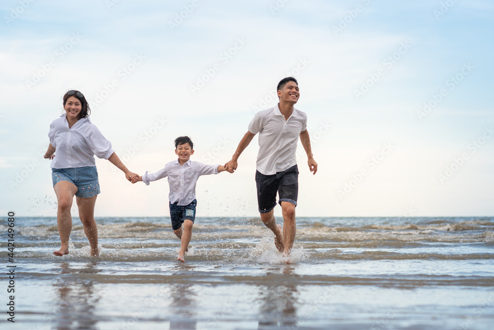 a happy family having fun on a beach a happy family having fun on a beach