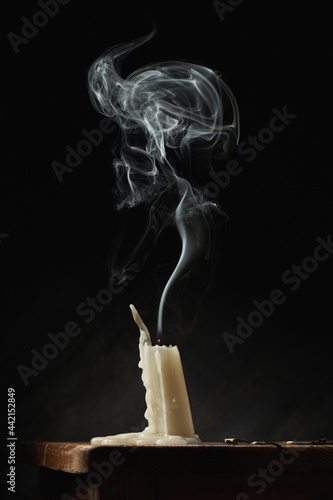 Extinguished candle on black background photo