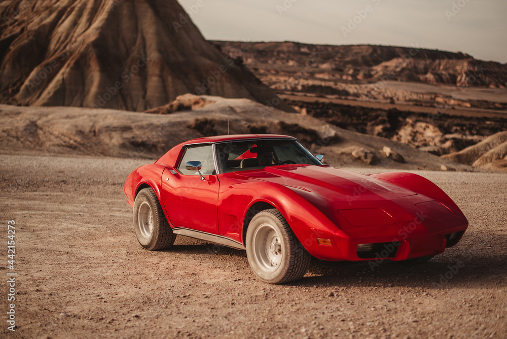 Sports car parked near mountain in desert Sports car parked near mountain in desert