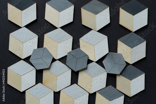 3d wooden cubes (hexagons) hand painted in white and various shades of gray acrylic paint, loosely arranged on a medium gray paper background, and photographed from above in a flat lay style with ambi © eugen