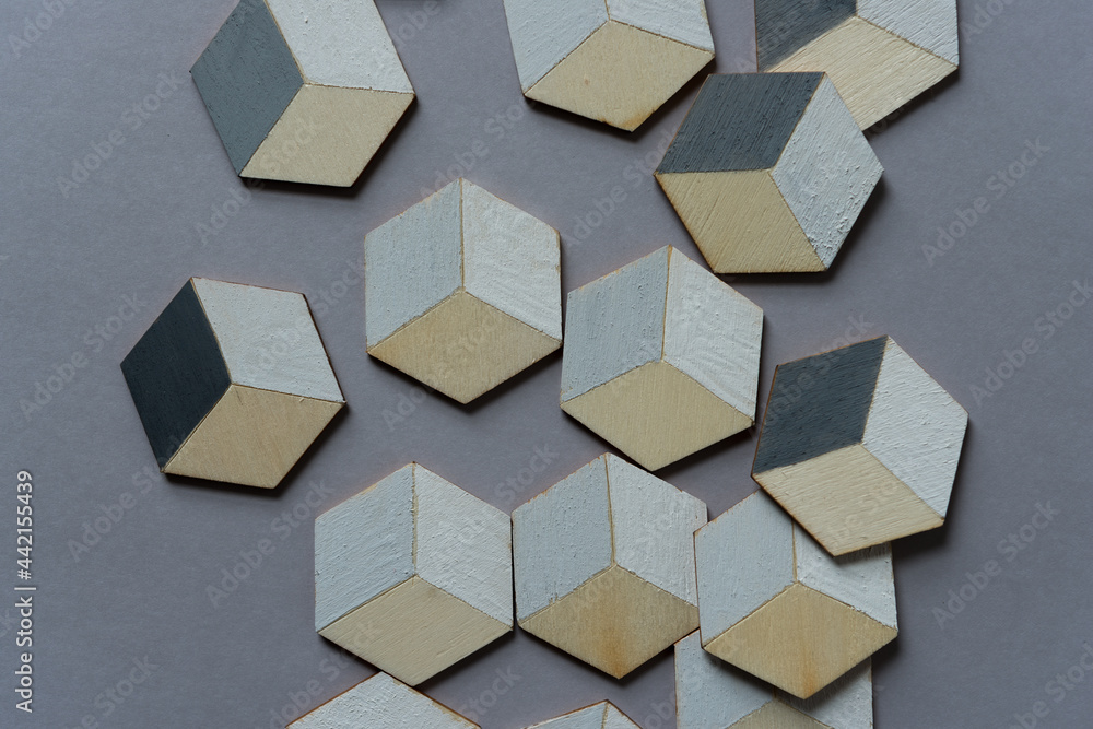 3d wooden cubes (hexagons) hand painted in white and various shades of gray acrylic paint, loosely arranged on a medium gray paper background, and photographed from above in a flat lay style with ambi 3d wooden cubes (hexagons) hand painted in white and various shades of gray acrylic paint, loosely arranged on a medium gray paper background, and photographed from above in a flat lay style with ambi