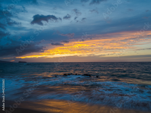 Colored sky over the sea. Waves on the sand. Amazing sunset at Maluaka Beach, Maui Island. Beautiful nature of Hawaii