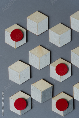 hand painted wooden shapes--hexagons  squares  circles  hearts--in gray  white  and red - loosely arranged on a gray background