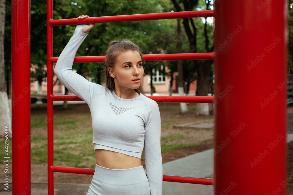 Portrait of a beautiful sportswoman. Fitness, workout, outdoor. Trained muscular body. Park, sports ground. A healthy lifestyle.