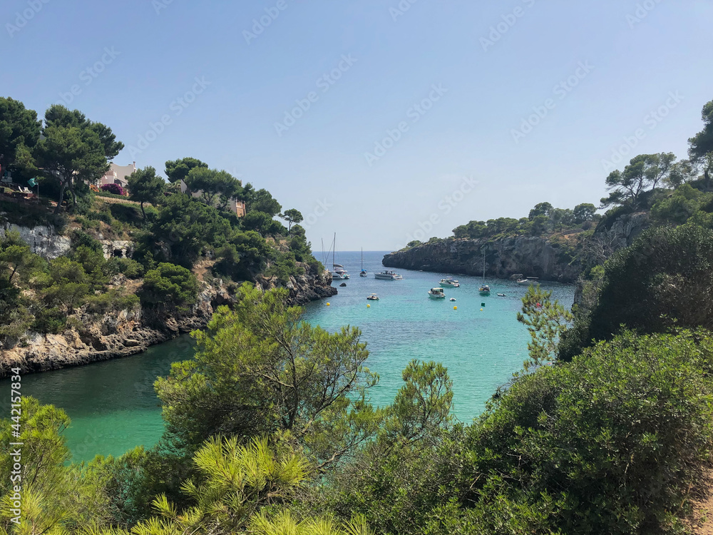 Cala Pi bay in the southern part of Mallorca with crystal clear turquoise water and sailing yachts