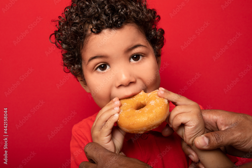 Cute boy eating donut in studio Cute boy eating donut in studio