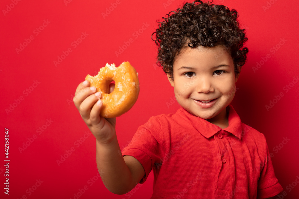 Cute boy eating donut in studio Cute boy eating donut in studio