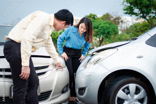 Two drivers check for damage after a car accident before taking pictures and sending insurance. Online car accident insurance claim idea after submitting photos and evidence to an insurance company. © Prot