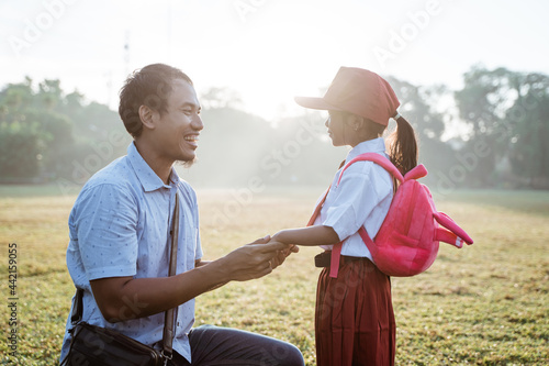 father taking her daughter to primary school in the morning. back to school concept © Odua Images