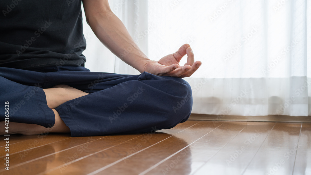 自宅でヨガをする男性。瞑想ポーズ。 自宅でヨガをする男性。瞑想ポーズ。