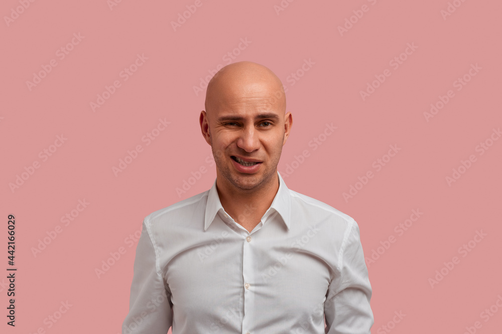 Ugh how can you eat this. Photo of doubtful annoyed bald guy with bristle, looking at camera, wary of something nasty. Dressed in white shirt, isolated violet color background. Ugh how can you eat this. Photo of doubtful annoyed bald guy with bristle, looking at camera, wary of something nasty. Dressed in white shirt, isolated violet color background.