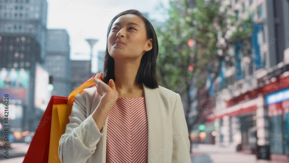 Portrait of Beautiful Japanese Female Wearing Smart Casual Clothes on the Street. Successful Female Putting Shopping Bags on Her Shoulder in Big Urban City Environment Living the Urban Lifestyle. Portrait of Beautiful Japanese Female Wearing Smart Casual Clothes on the Street. Successful Female Putting Shopping Bags on Her Shoulder in Big Urban City Environment Living the Urban Lifestyle.