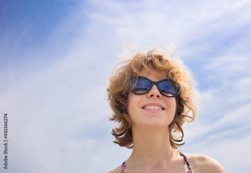 close-up face of a beautiful young woman in sunglasses against the background of the sky. enjoying nature outdoors, relaxation, summer mood, heat. Romance, sunbathing. Copy space close-up face of a beautiful young woman in sunglasses against the background of the sky. enjoying nature outdoors, relaxation, summer mood, heat. Romance, sunbathing. Copy space