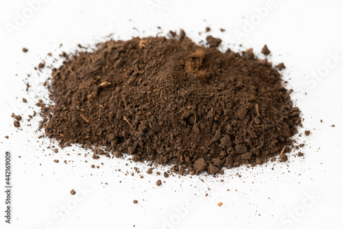 A pile of black dark brown peat, a natural fertilizer formed from particles of dead bog plants. Loose sedimentary rock that is used as a combustible mineral on a white background
