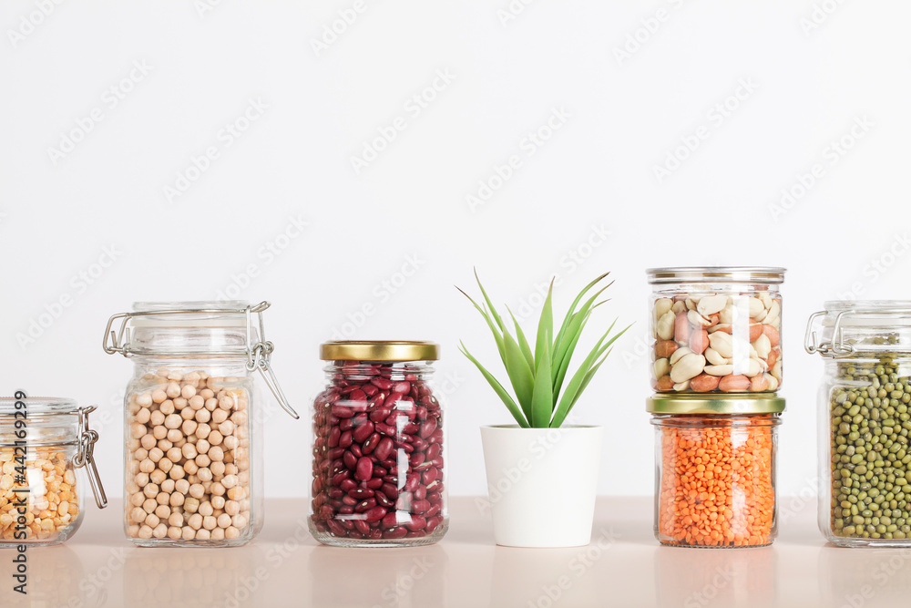 Vegan protein source. Beans, peas, chickpeas, lentils, mung, peanut in glass jars on white and beige background. Healthy vegetarian food. copy space Vegan protein source. Beans, peas, chickpeas, lentils, mung, peanut in glass jars on white and beige background. Healthy vegetarian food. copy space