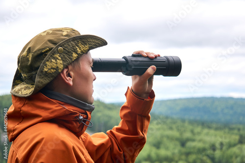 Fotografi male traveler looking into the distance in spotting scope