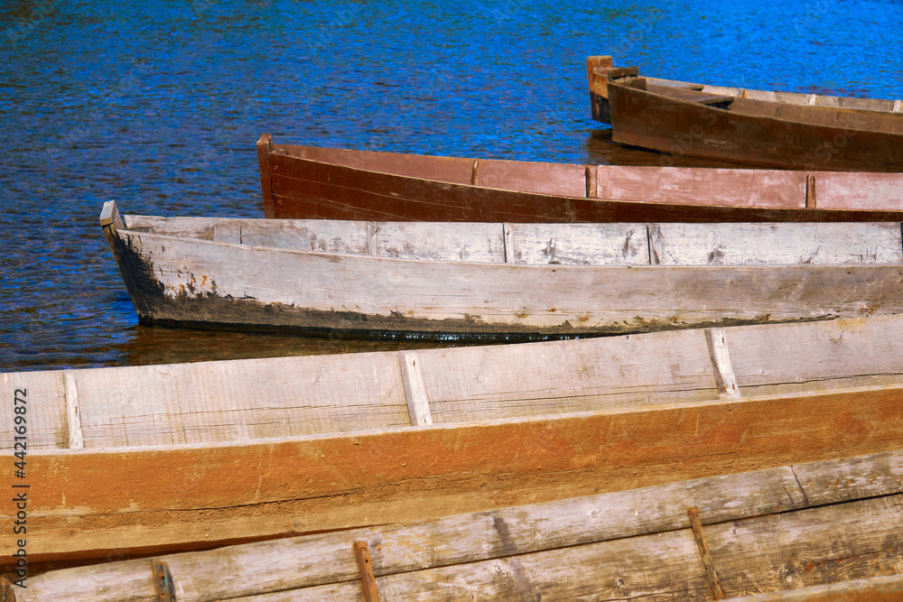 Obraz premium traditional wooden flat-bottomed boats on the river bank, rural landscape