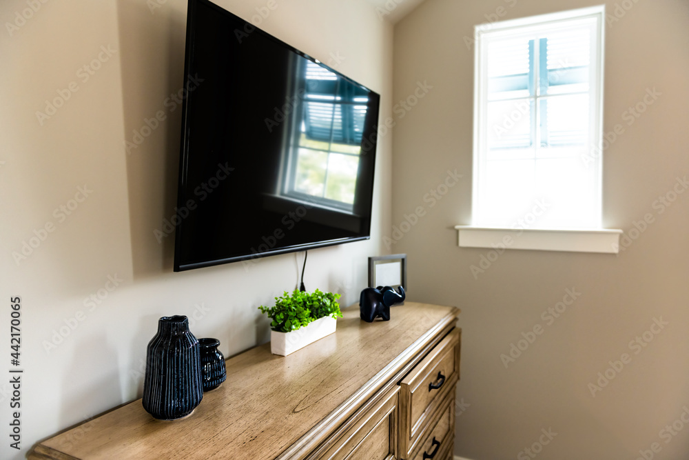 Table in small living room or bedroom with style design and nobody in house home with television mounted to wall and neutral colors Table in small living room or bedroom with style design and nobody in house home with television mounted to wall and neutral colors