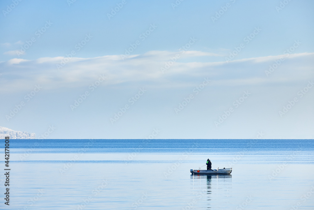 Fototapeta premium Deutschland, Baden-Württemberg, Bodensee, Überlingen am Bodensee, Winterlandschaft, Blick auf den Bodensee, Angler in einem Boot 