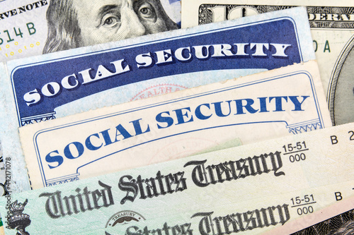Macro view of Social Security cards, United States Treasury checks and cash. photo