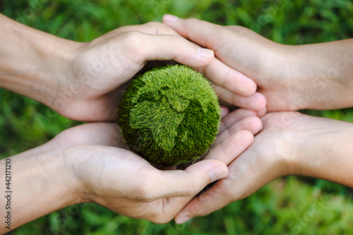 top view of teamwork hands holding the earth on a green background. protect nature. Save Earth. concept of the environment World Earth Day. ecology and environment sustainable concept.