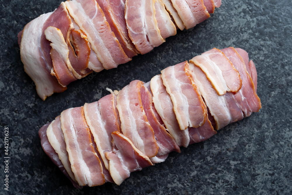 close up of bacon wrapped pork tenderloin raw uncooked