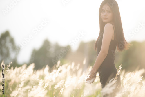 Portrait of beautiful asian woman at grass field on sunset