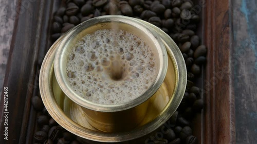 Serving Indian Filter Coffee in a brass cup photo