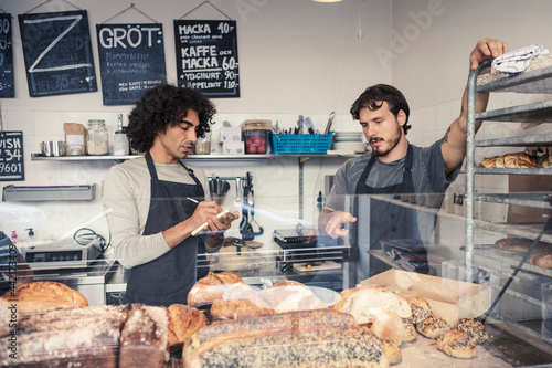 Entreprenörer diskuterar och antecknar på café photo