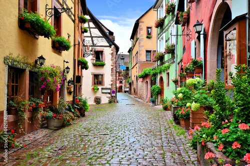 Quaint colorful cobblestone lane in the Alsatian town of Riquewihr, France © Jenifoto