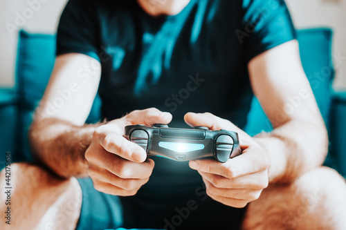 A man enthusiastically plays a game console using a gamepad