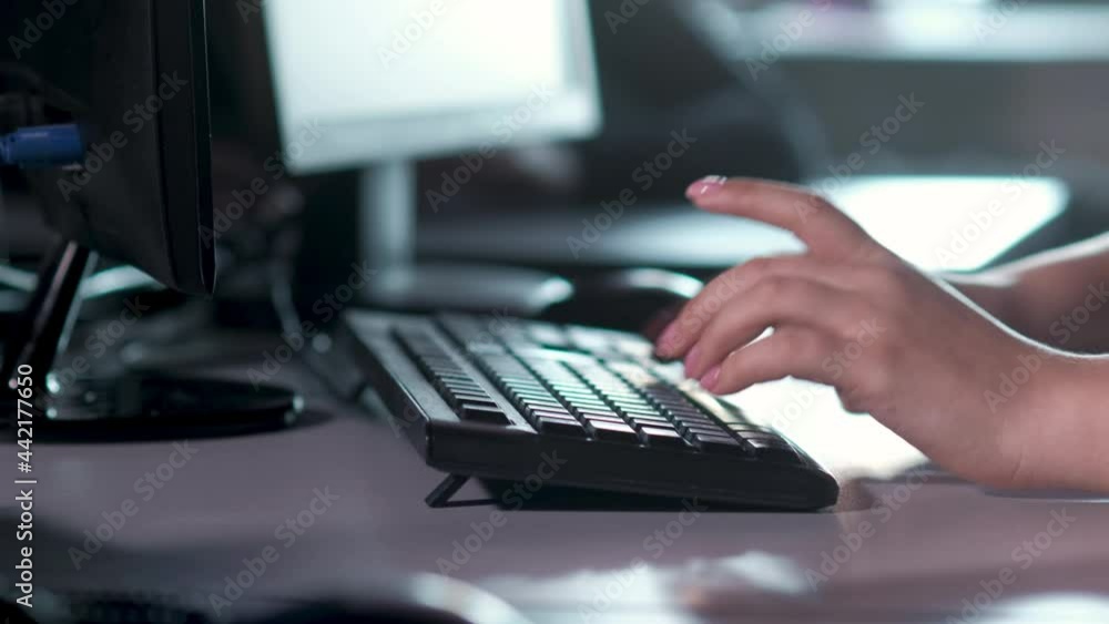 Call center and customer service assistance. customer support specialist in office types on the computer keyboard, advises client on phone.