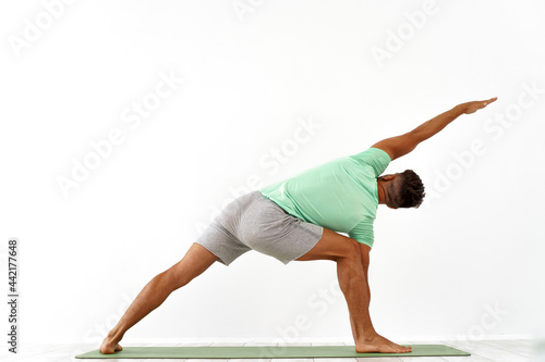 back view of sporty man practicing yoga in yoga class, making stretching back. Healthy lifestyle, Yoga Practice Exercise Class Concept