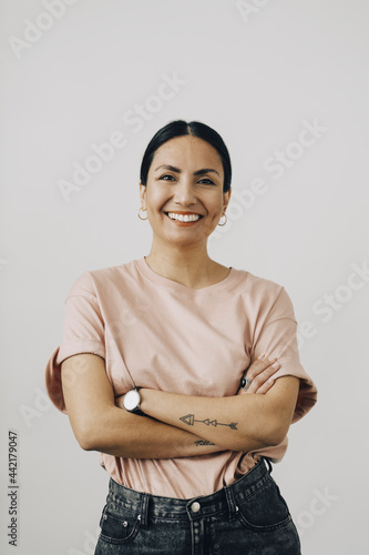 Porträtt av glad kvinna med armarna i kors photo