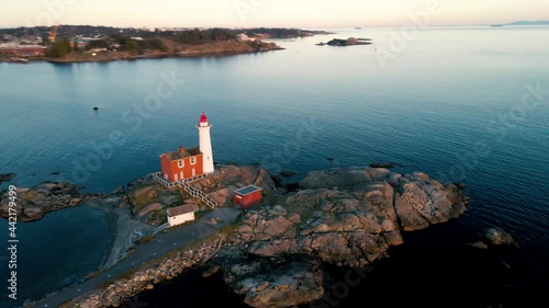 A 4K aerial shot of the Fisgard Lighthouse at sunset in Esquimalt Harbour, British Columbia, Canada photo
