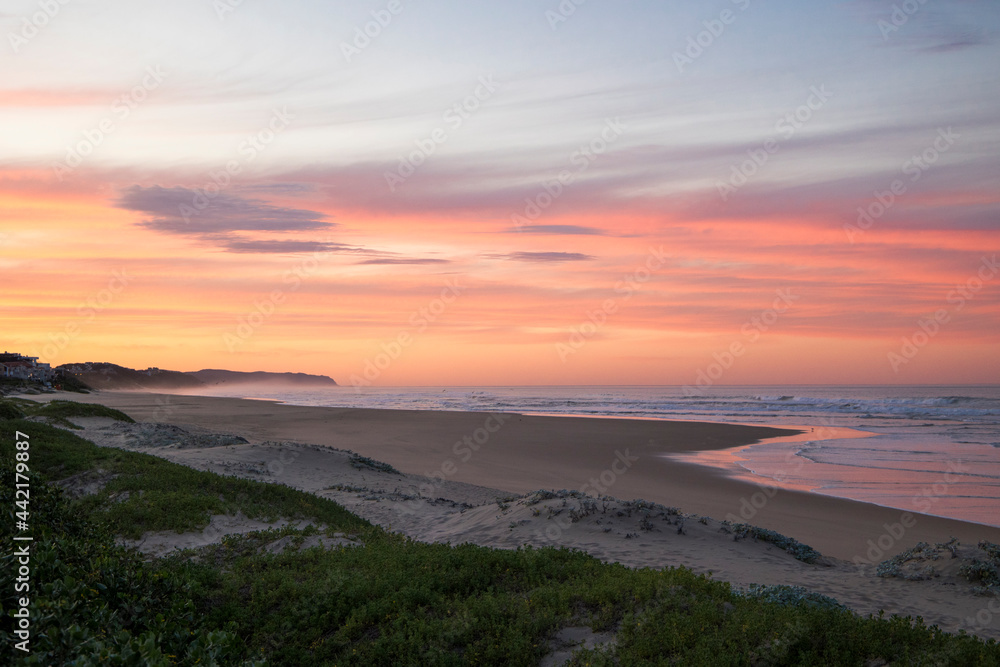 A coastal landscape scene with a beautiful pink sunrise