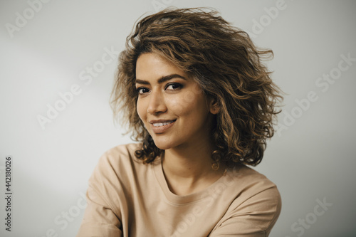 Porträtt av leende kvinna med brunt lockigt hår