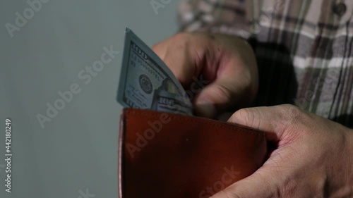 Leather wallet with money in male hands.businessman hands put money in brown leather wallet on dark background.Concept of savings, salary, payment and funds.4K 2160p 30 fps UltraHD footage