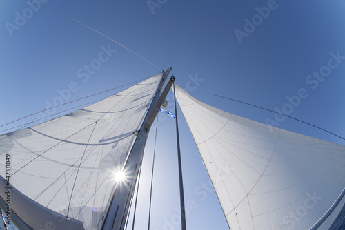 Sailboat with butterfly sails in backlight