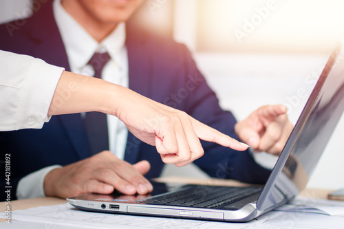Image of a young businessman using touchpad at the meeting with his colleague. The concept is to report investment results.