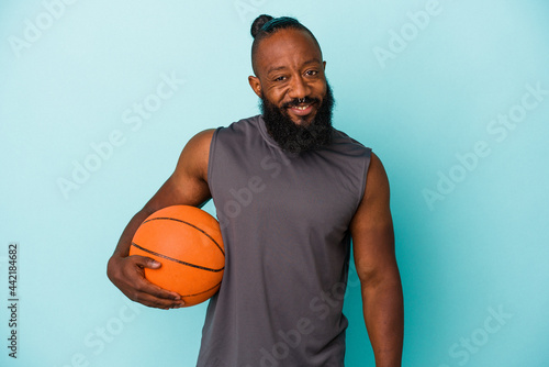 African american man playing basketball isolated on blue background happy, smiling and cheerful.