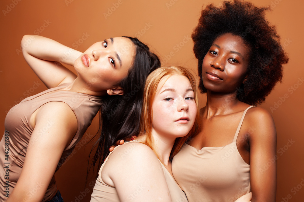 young pretty asian, caucasian, afro woman posing cheerful together on brown background, lifestyle diverse nationality people concept young pretty asian, caucasian, afro woman posing cheerful together on brown background, lifestyle diverse nationality people concept