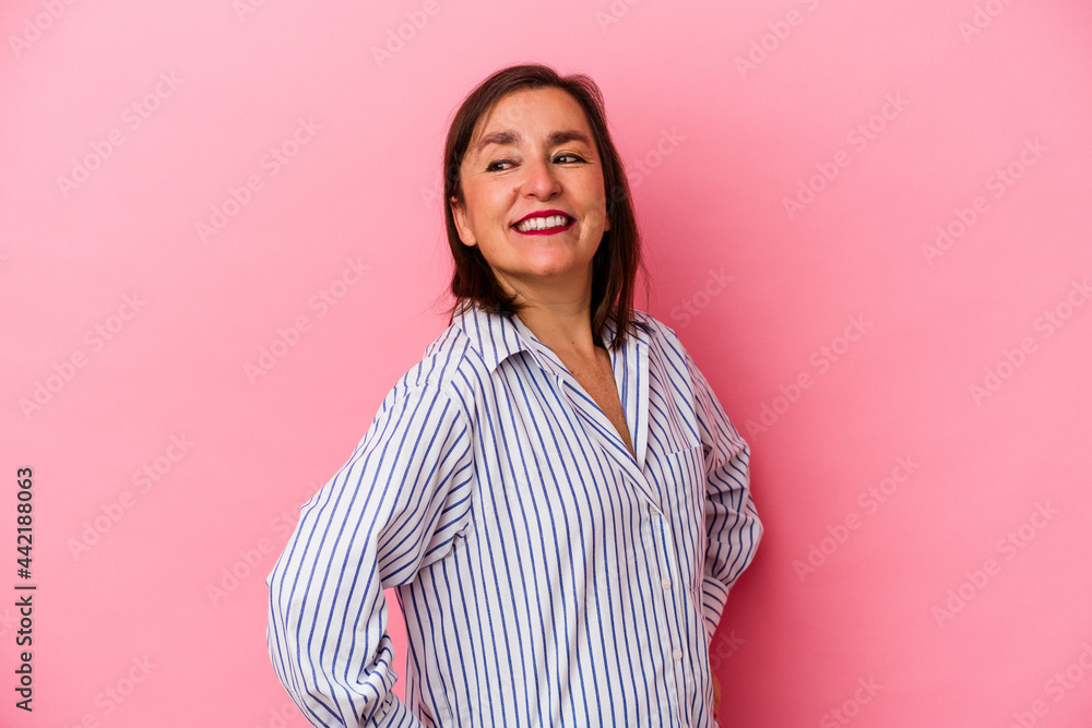 Fototapeta premium Middle age caucasian woman isolated on pink background laughs happily and has fun keeping hands on stomach.