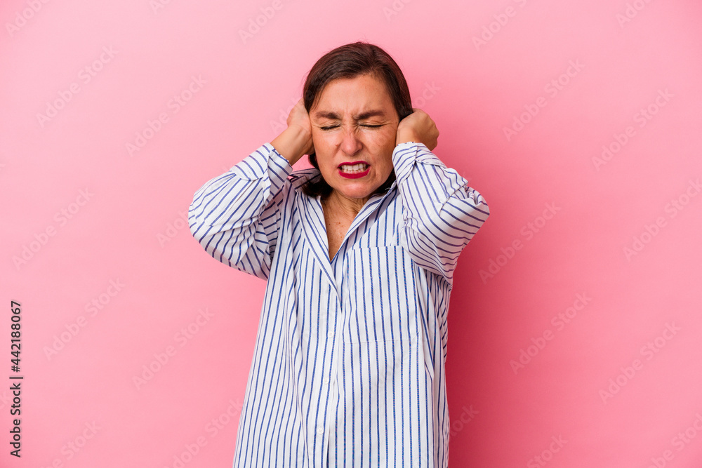 Middle age caucasian woman isolated on pink background covering ears with hands. Middle age caucasian woman isolated on pink background covering ears with hands.