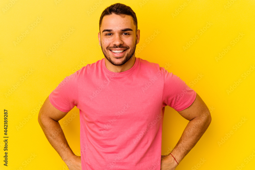Young caucasian man isolated on yellow background confident keeping hands on hips. Young caucasian man isolated on yellow background confident keeping hands on hips.