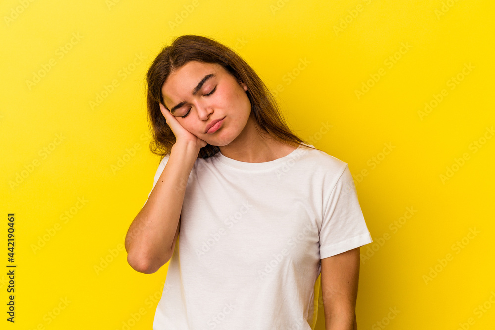 Young caucasian woman isolated on yellow background who is bored, fatigued and need a relax day. Young caucasian woman isolated on yellow background who is bored, fatigued and need a relax day.