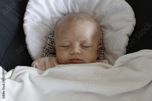 Un bébé dort tranquillement dans son transat