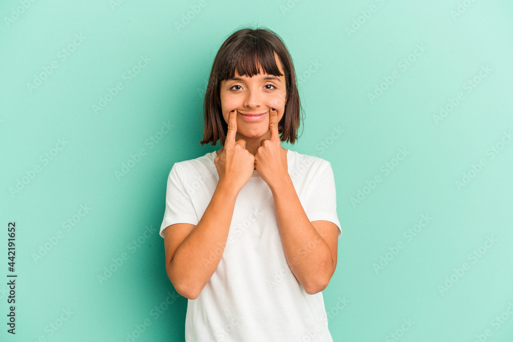 Young mixed race woman isolated on blue doubting between two options. Young mixed race woman isolated on blue doubting between two options.