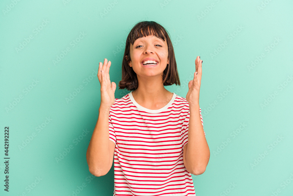 Young mixed race woman isolated on blue laughs out loudly keeping hand on chest. Young mixed race woman isolated on blue laughs out loudly keeping hand on chest.